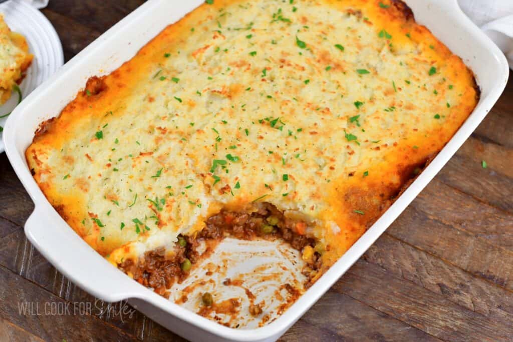 closeup shepherd's pie in the baking dish with some scooped out.