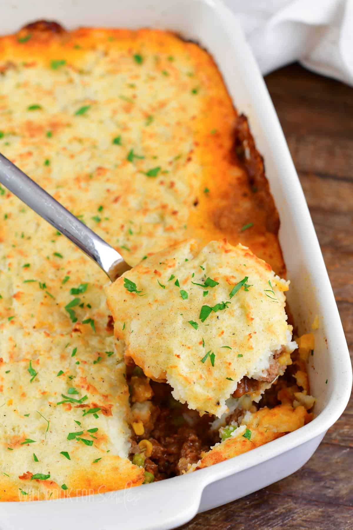 scooping out some shepherd's pie from the baking dish.