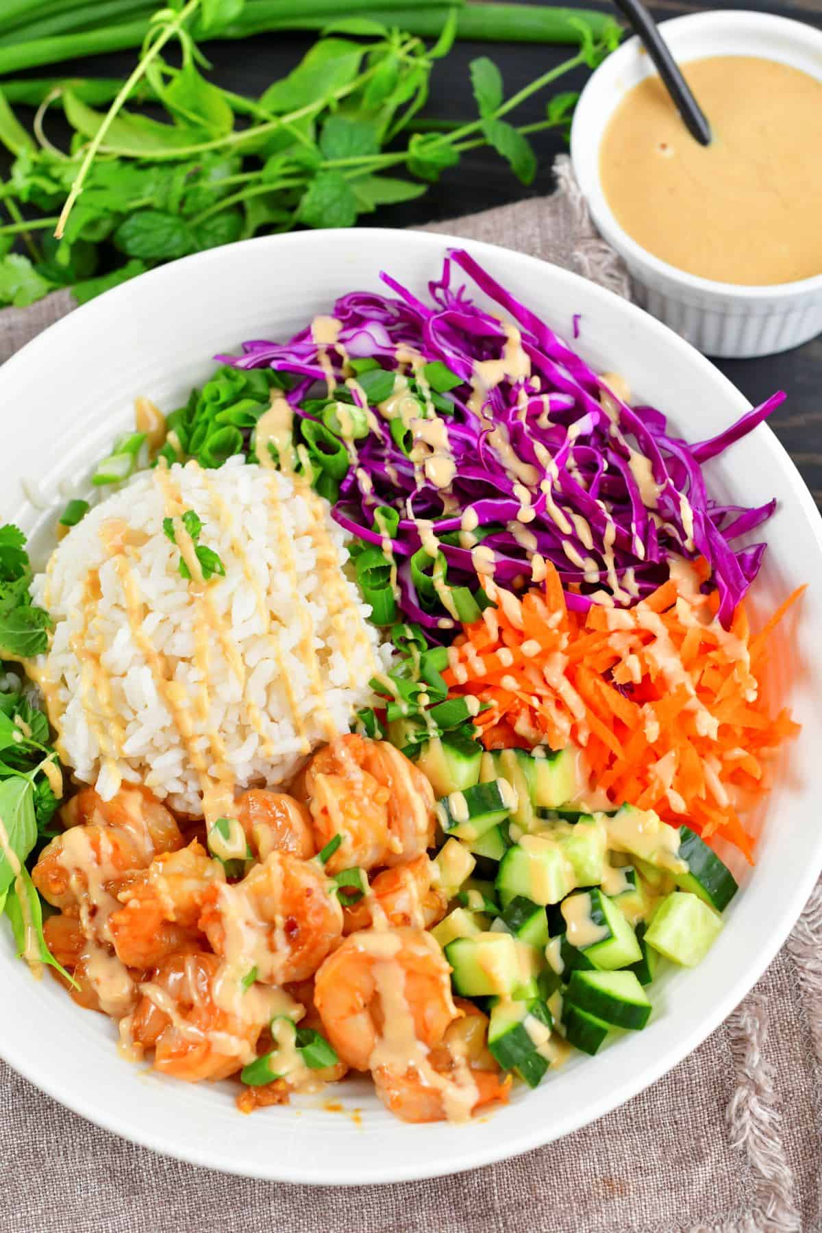 top view of spring rolls bowl with shrimp, rice, and veggies.
