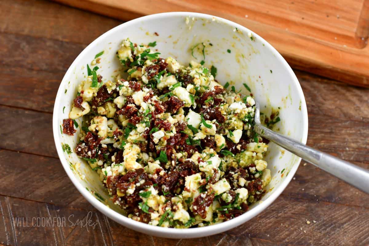 sun fried tomato, feta, and pesto filling in a white bowl.