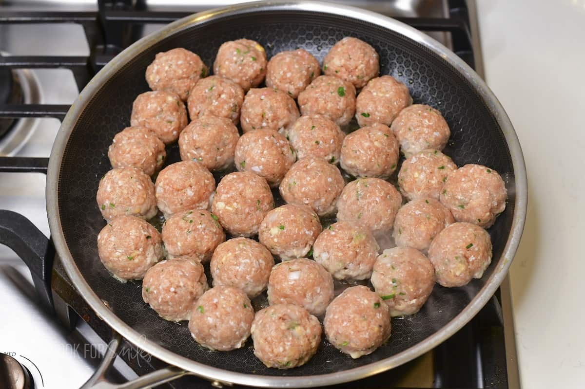 meatballs in the cooking pan starting to cook.