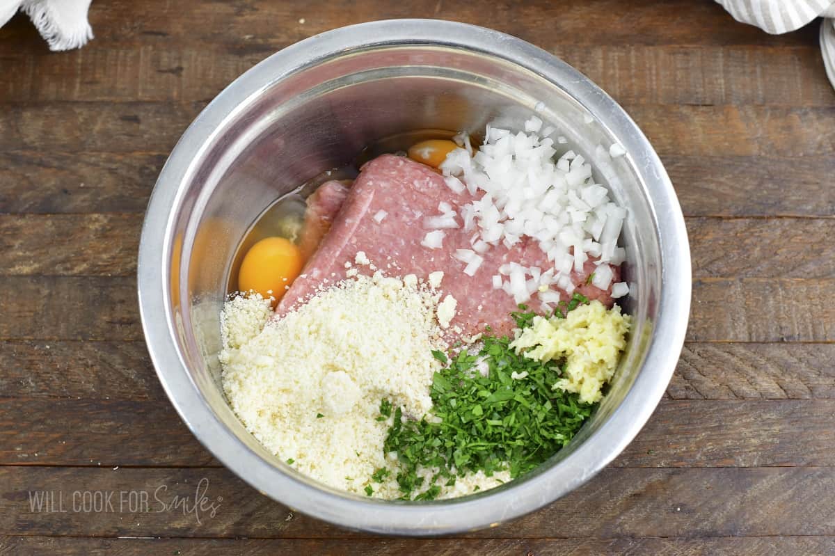 ingredients for the meatballs in a metal bowl.