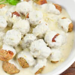 closeup squared view of creamy meatballs with parmesan.