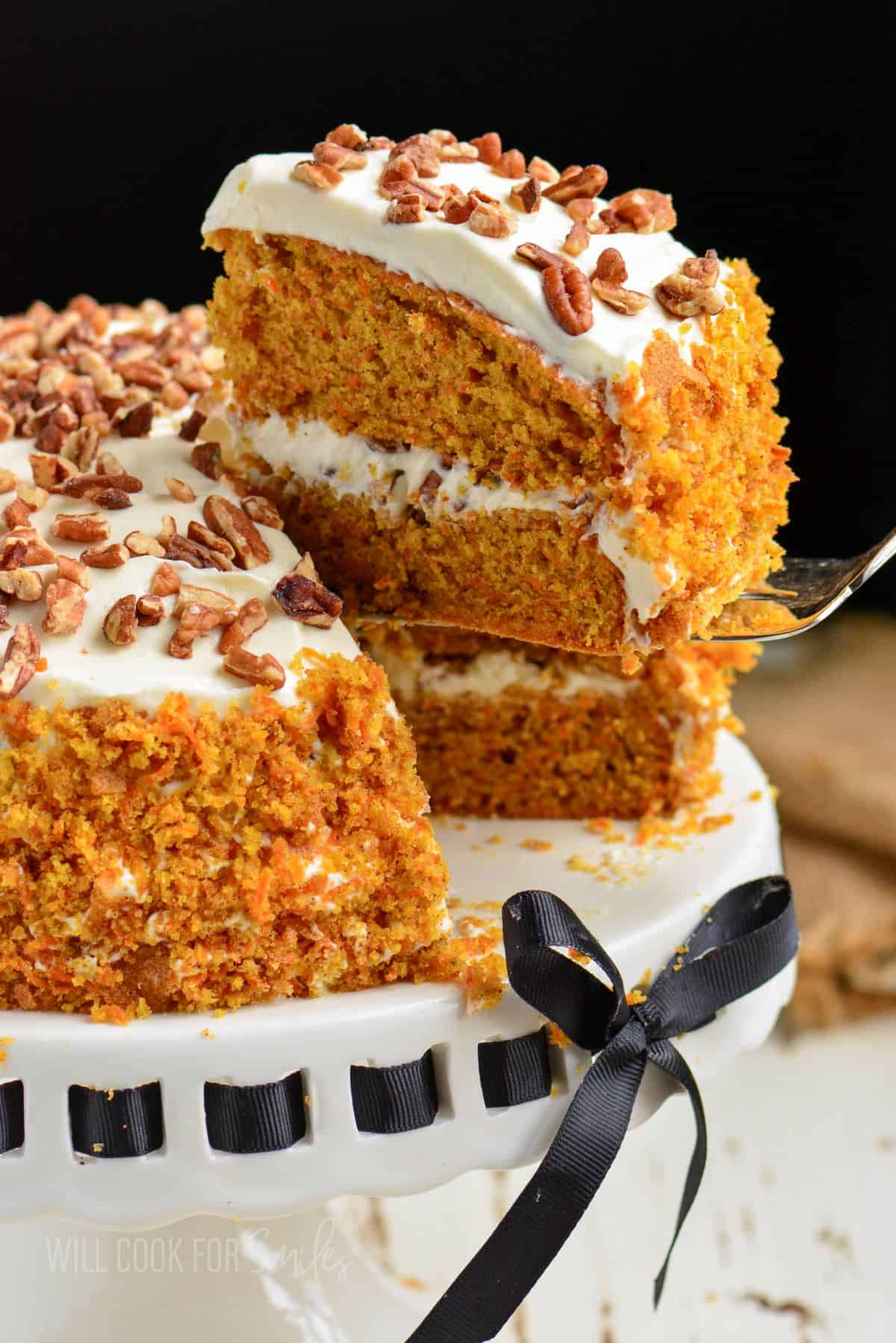 taking out a slice of carrot cake with a silver spatula.