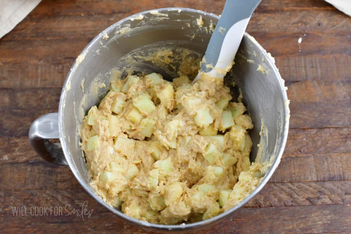 mixing in apple chunks into the cake.