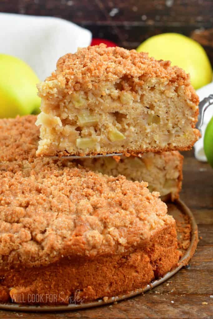 pulling out a slice of the apple cake from the whole.