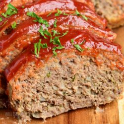 closeup of a slice of meatloaf topped with ketchup topping.