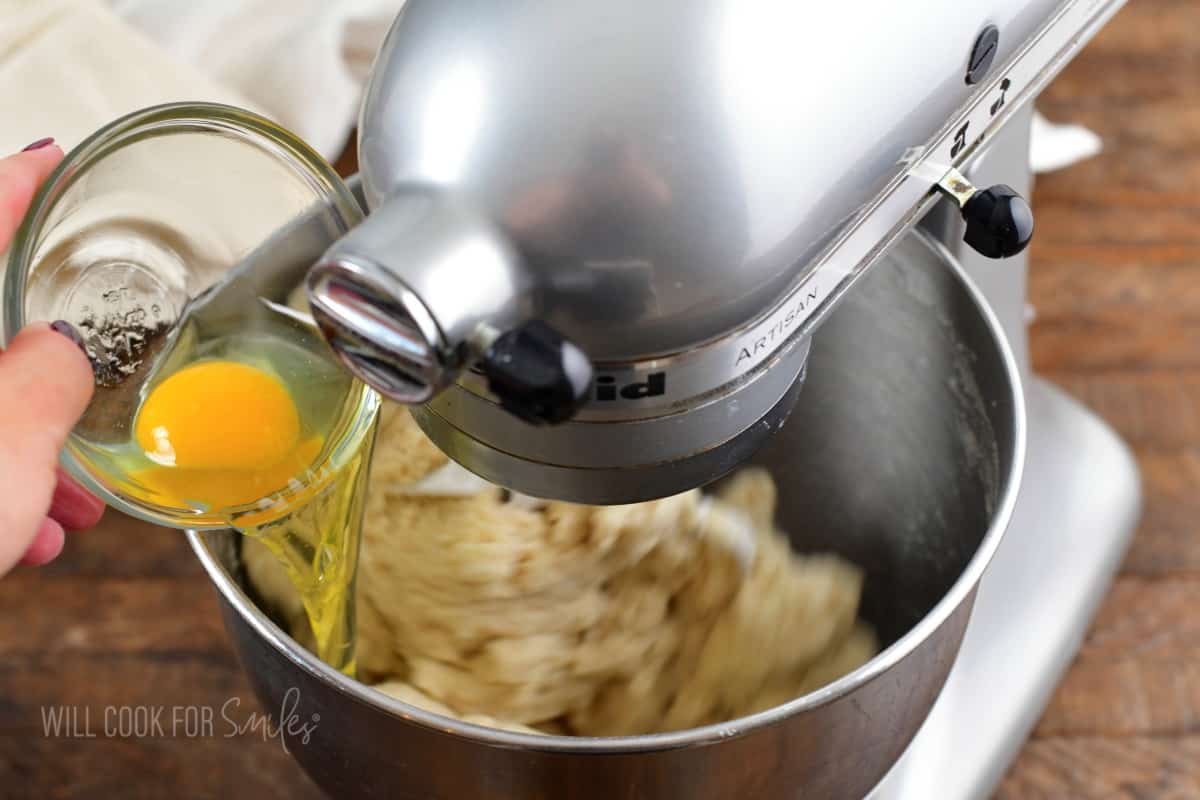 adding egg to the dough mixing in the electric mixer.