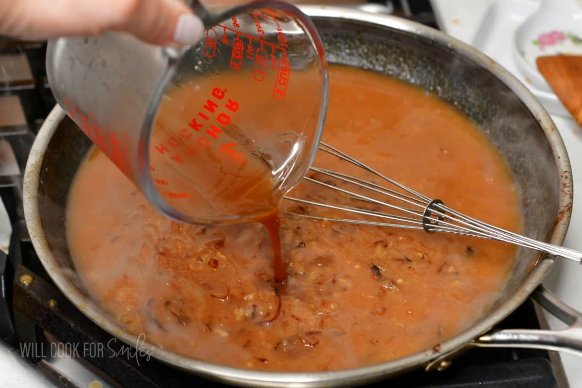 adding beef stock to the pan with gravy.