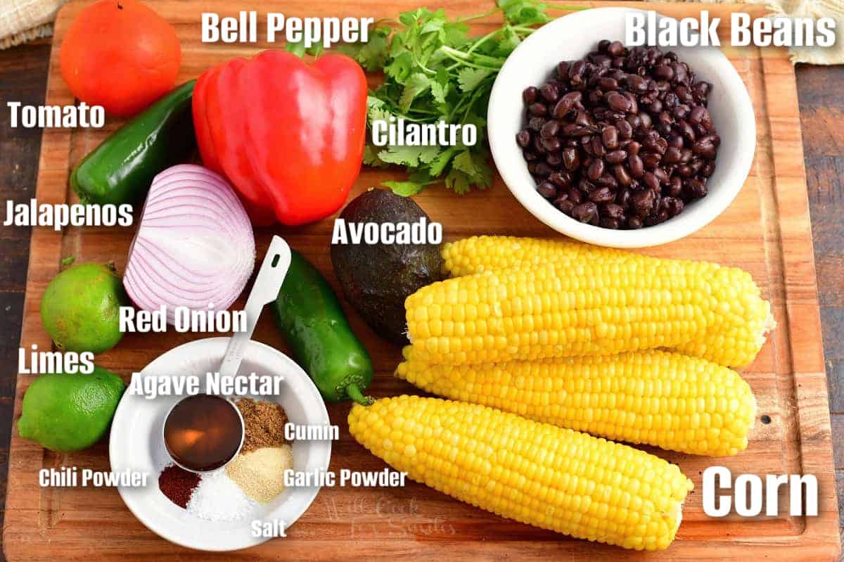 Labeled ingredients for black bean and corn salad are on a wooden surface.
