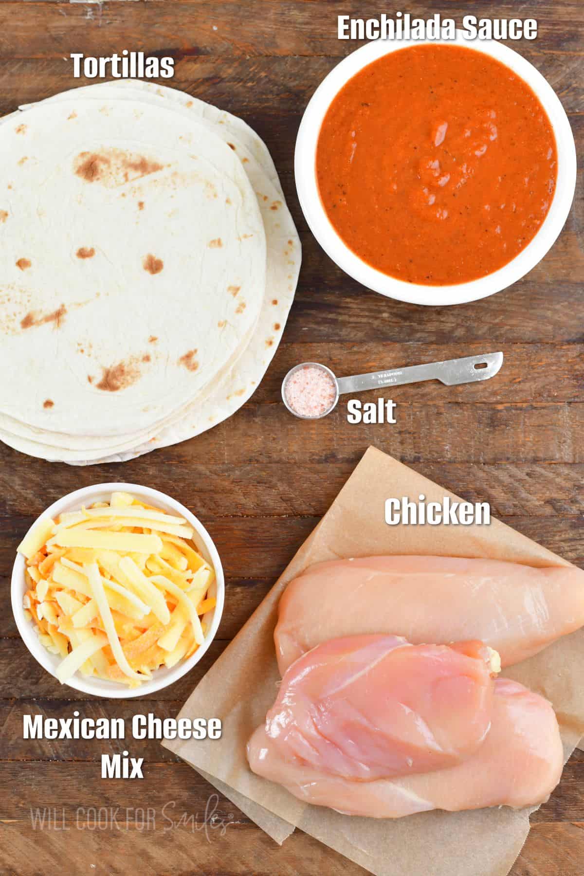 labeled ingredients to make chicken enchiladas on the wooden board.