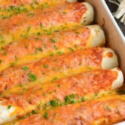 baked six chicken enchiladas in a white baking dish.