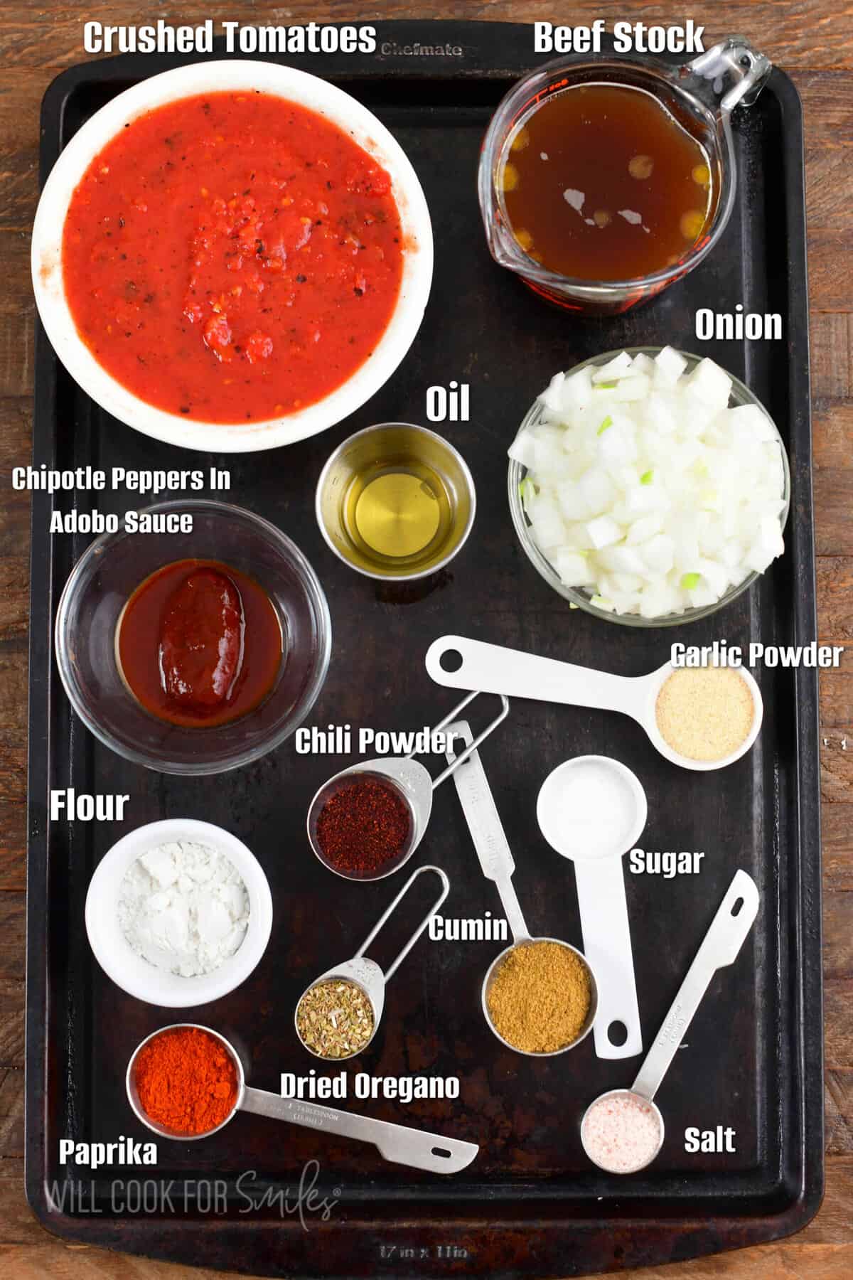 ingredients to make enchilada sauce on a metal sheet tray with labels.