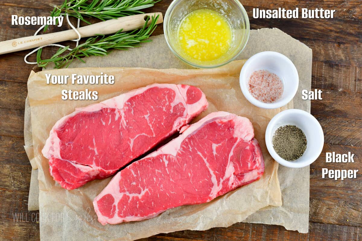 ingredients to cook steaks on the grill on wooden board with labels.