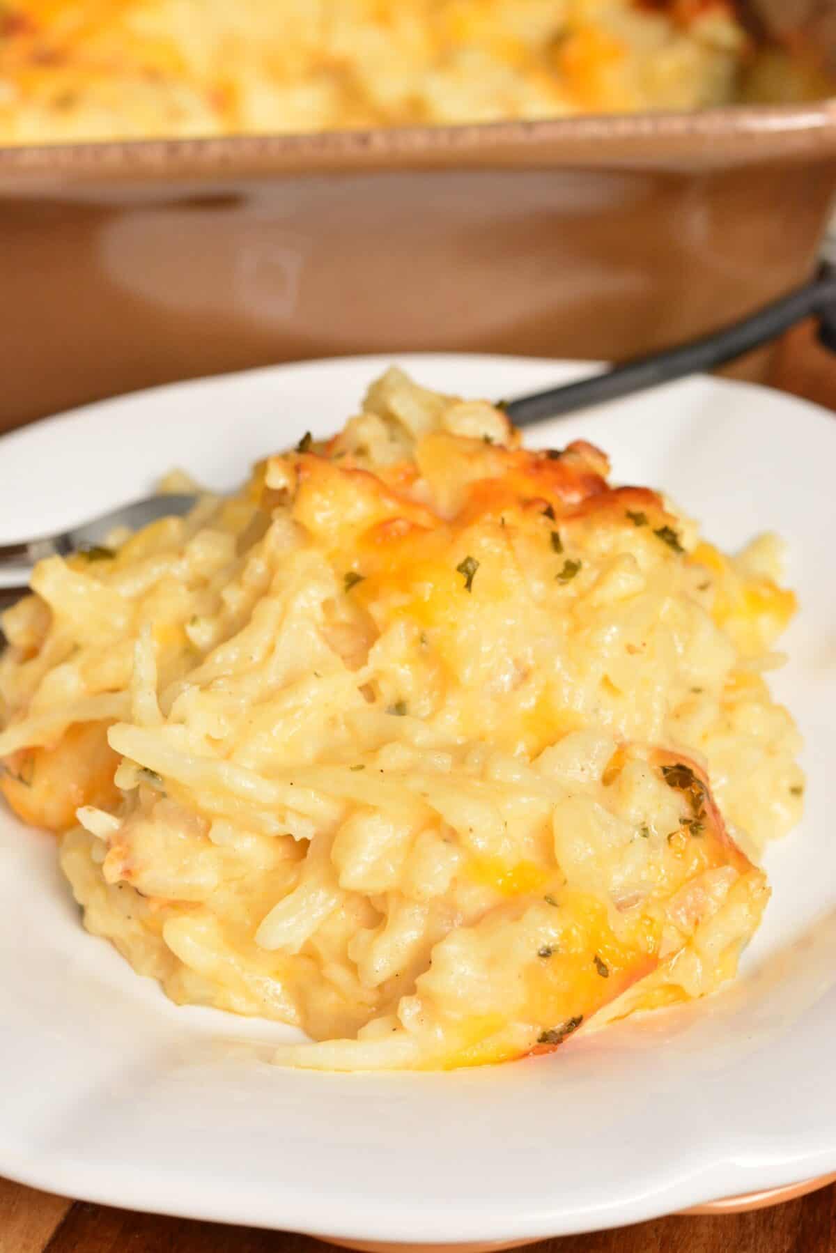 some hashbrown casserole on a white plate with a fork.