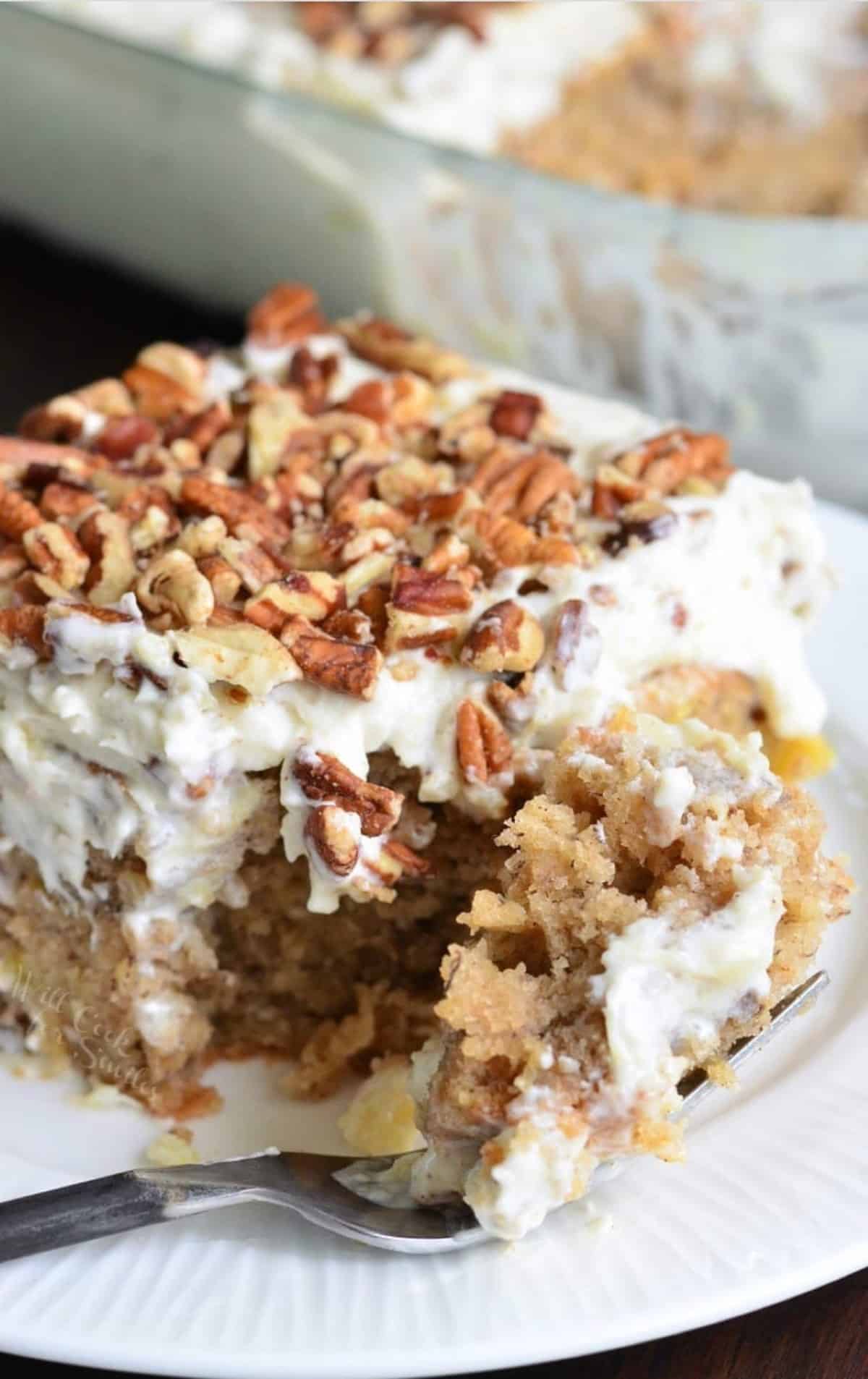 square slice of hummingbird cake with a piece take out with a fork.