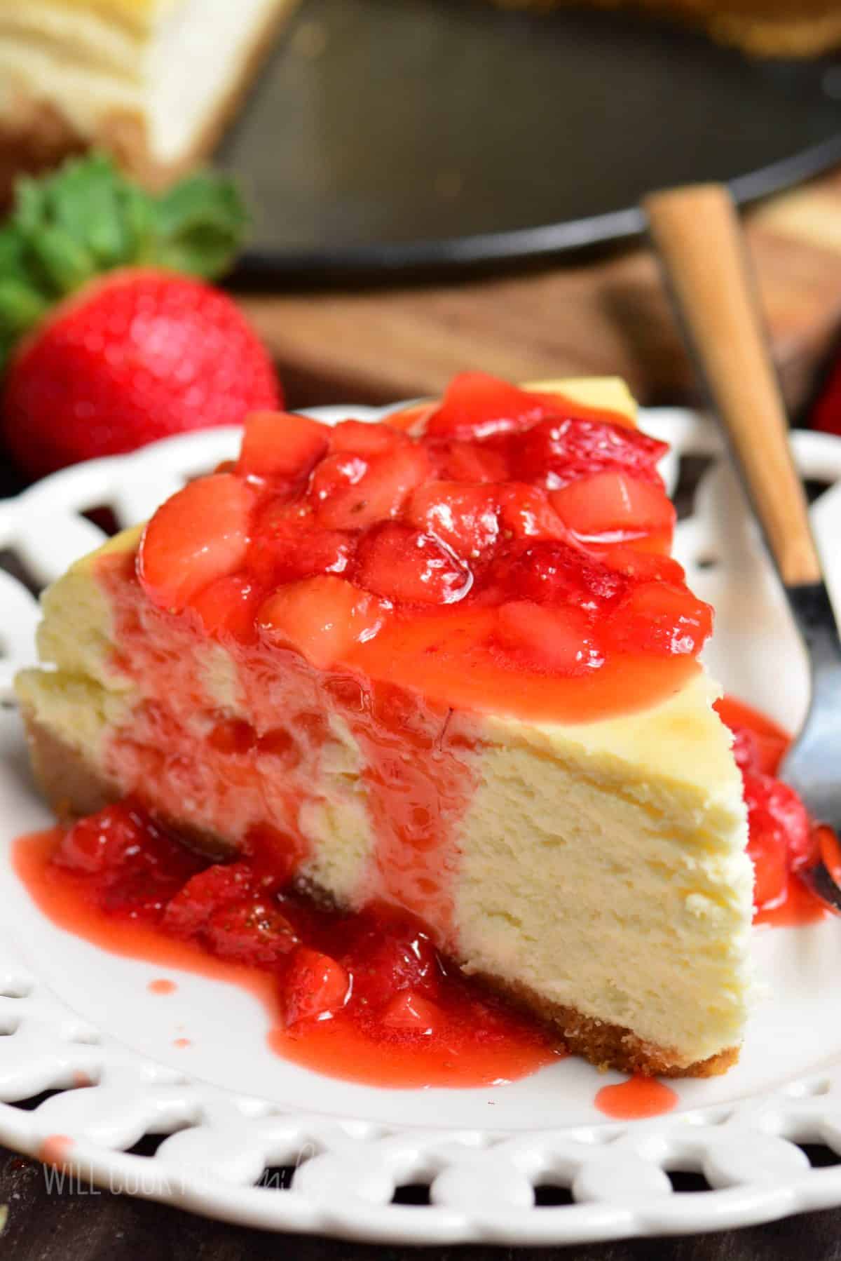 slice of NY cheesecake with strawberry topping on top.