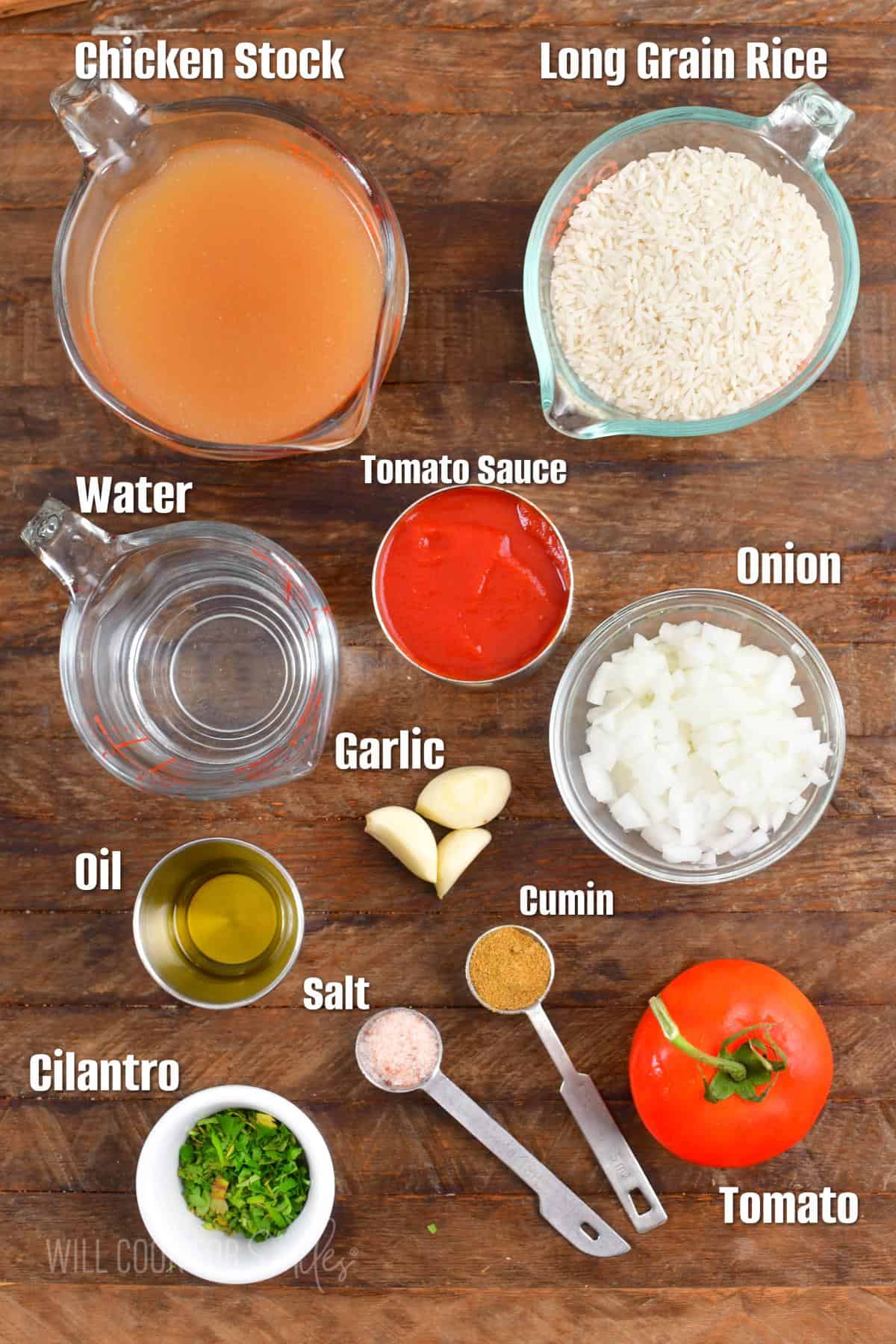 ingredients to make Spanish rice on wooden board and labeled.