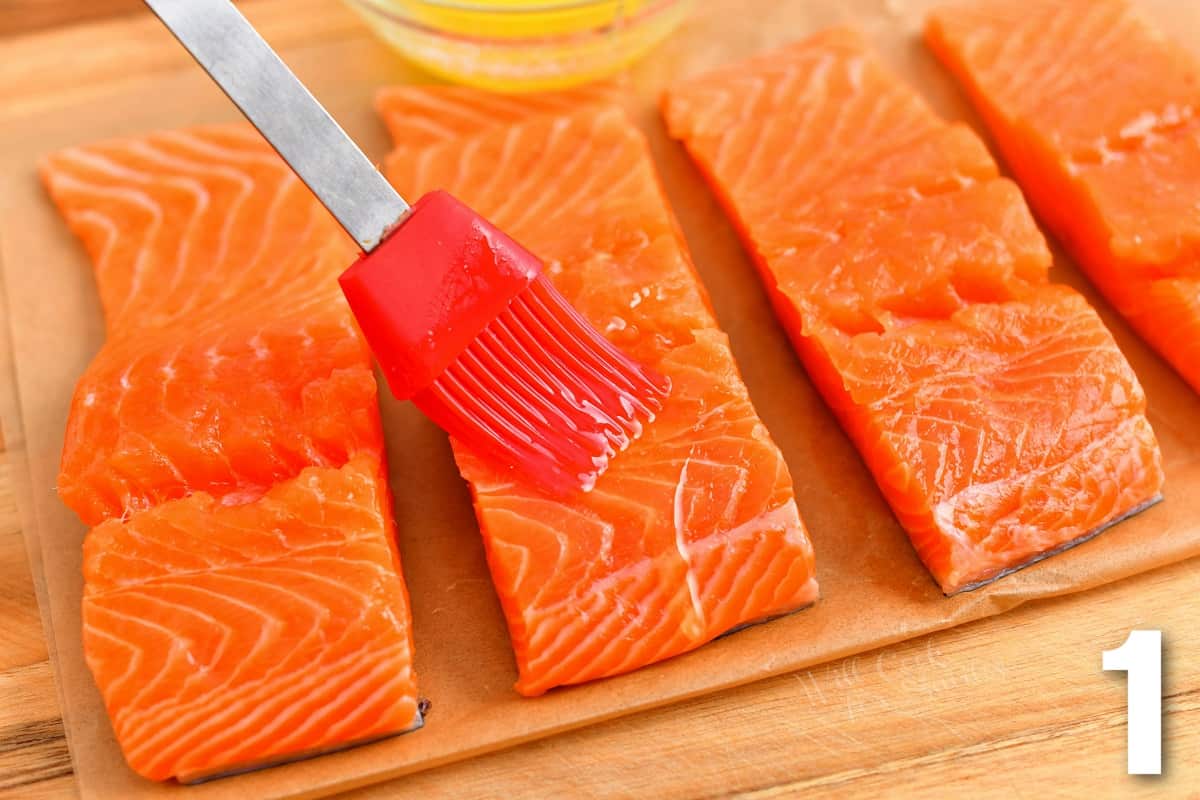 brushing salmon filets with melted butter before adding seasoning.