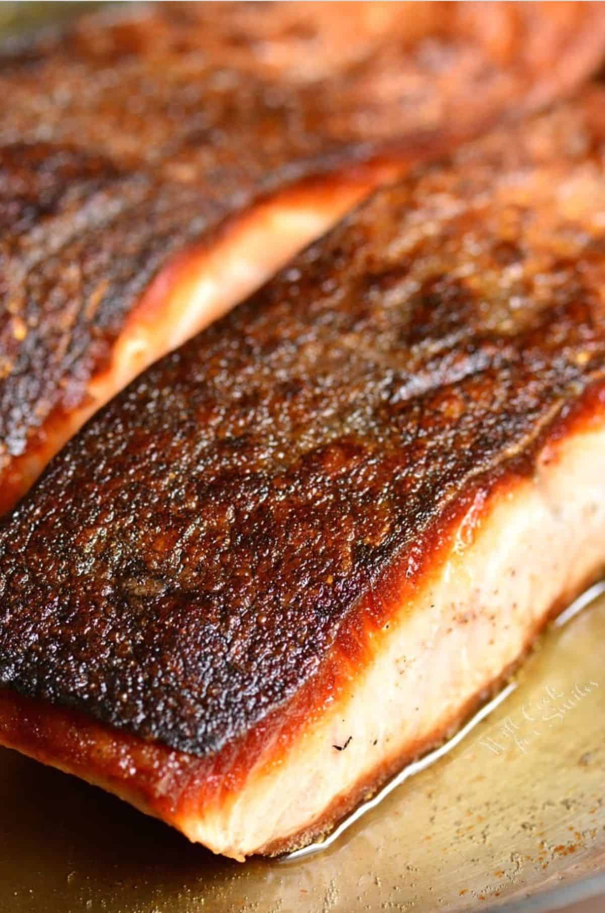 salmon filet in the pan with a brown crispy skin.