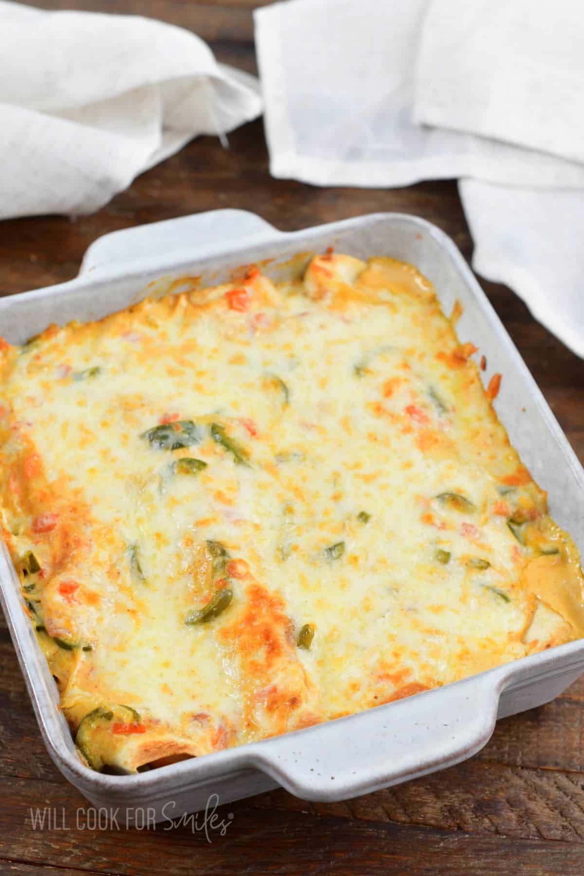 baked creamy shrimp enchiladas in the baking dish with melted cheese.