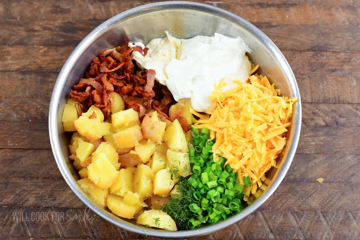 ingredients to make loaded baked potato salad in a mixing bowl.