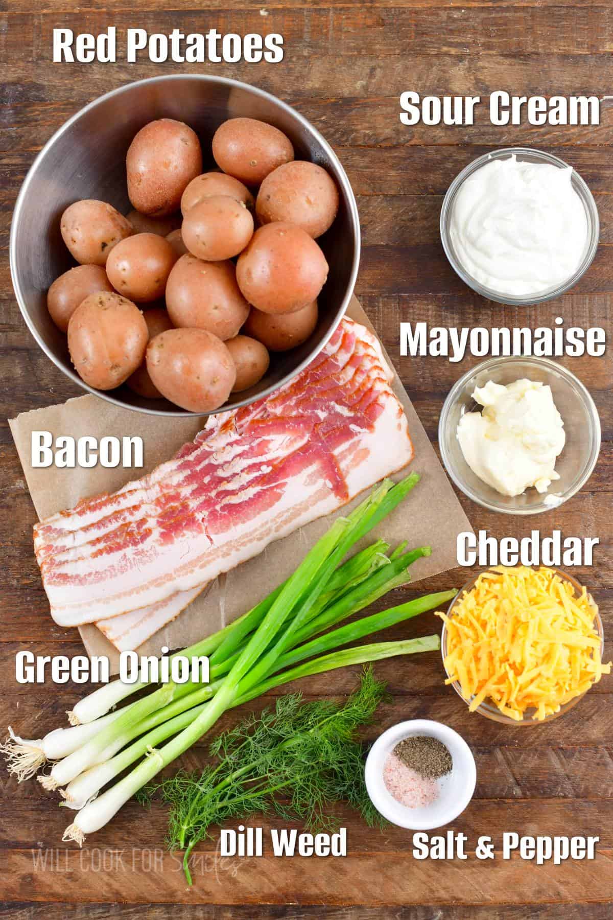 labeled ingredients to make loaded baked potato salad in the board.