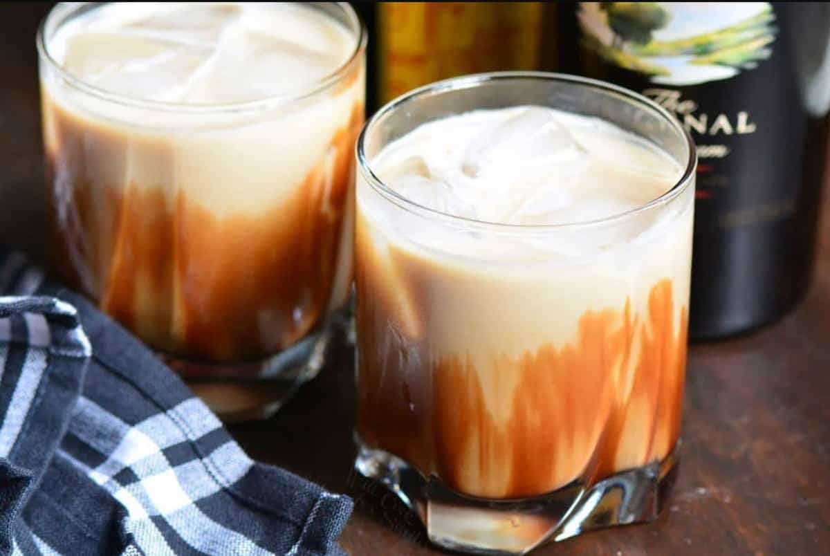 two glasses with creamy mud slide cocktail next to Bailey's bottle.