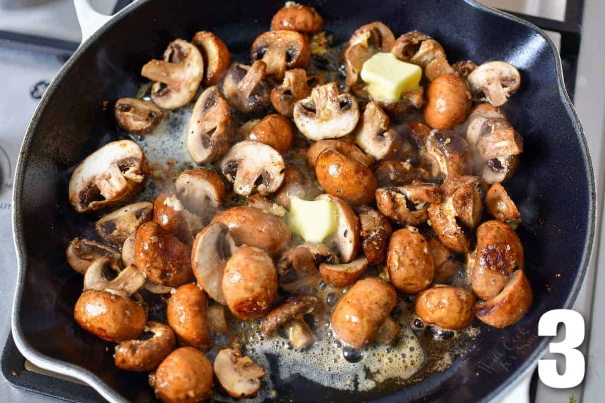adding butter to cooking mushrooms in the skillet.