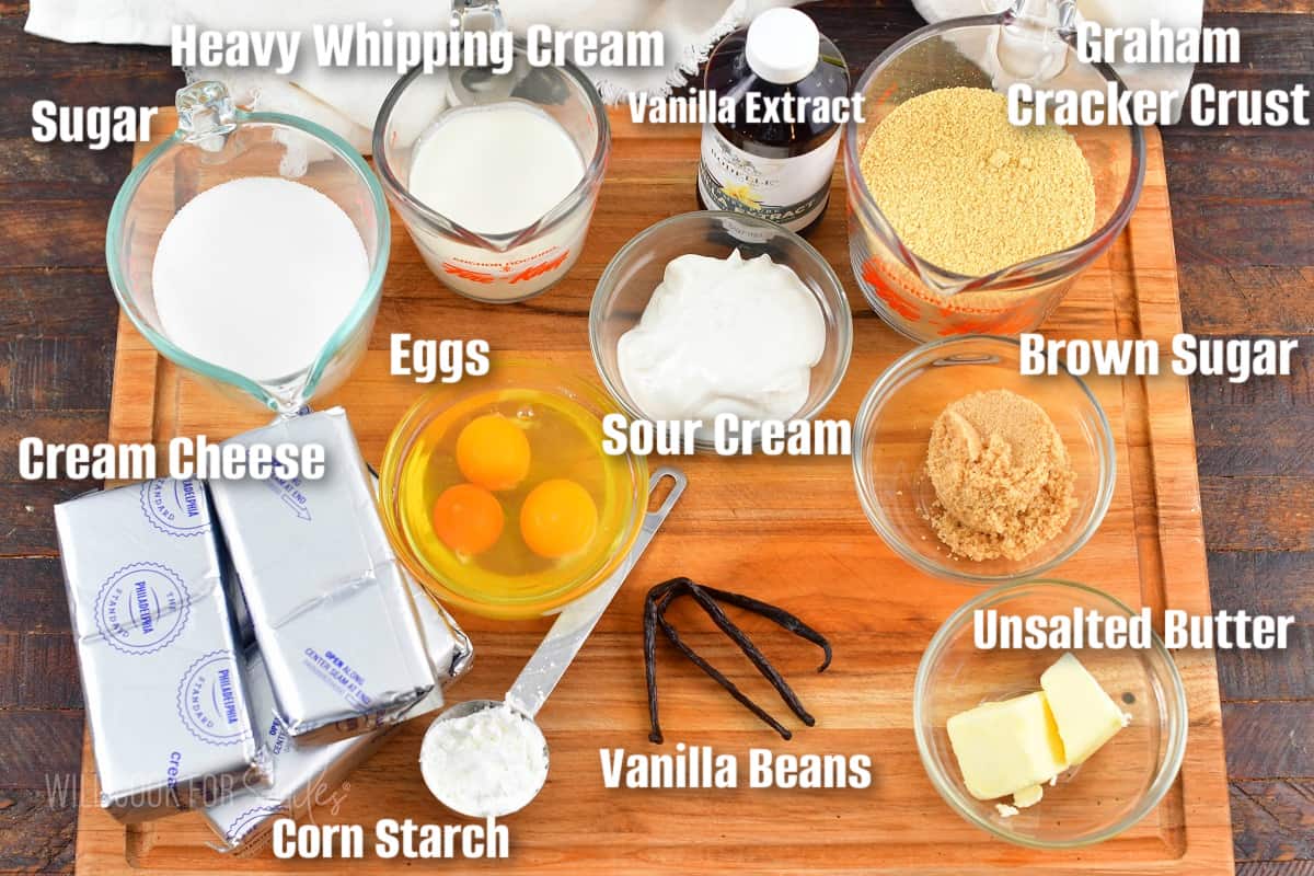 labeled ingredients to make vanilla bean cheesecake on the cutting board.