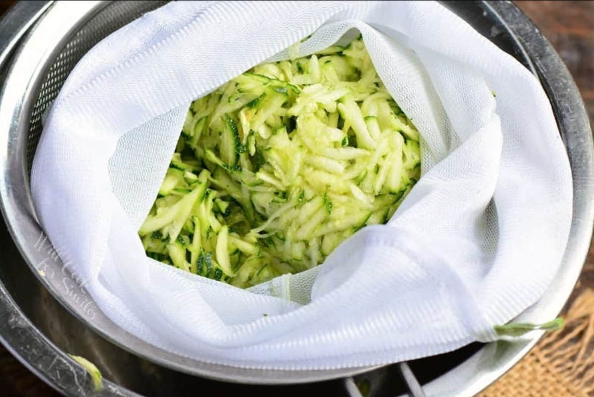 shaved zucchini in a mesh bag over the mixing bowl.
