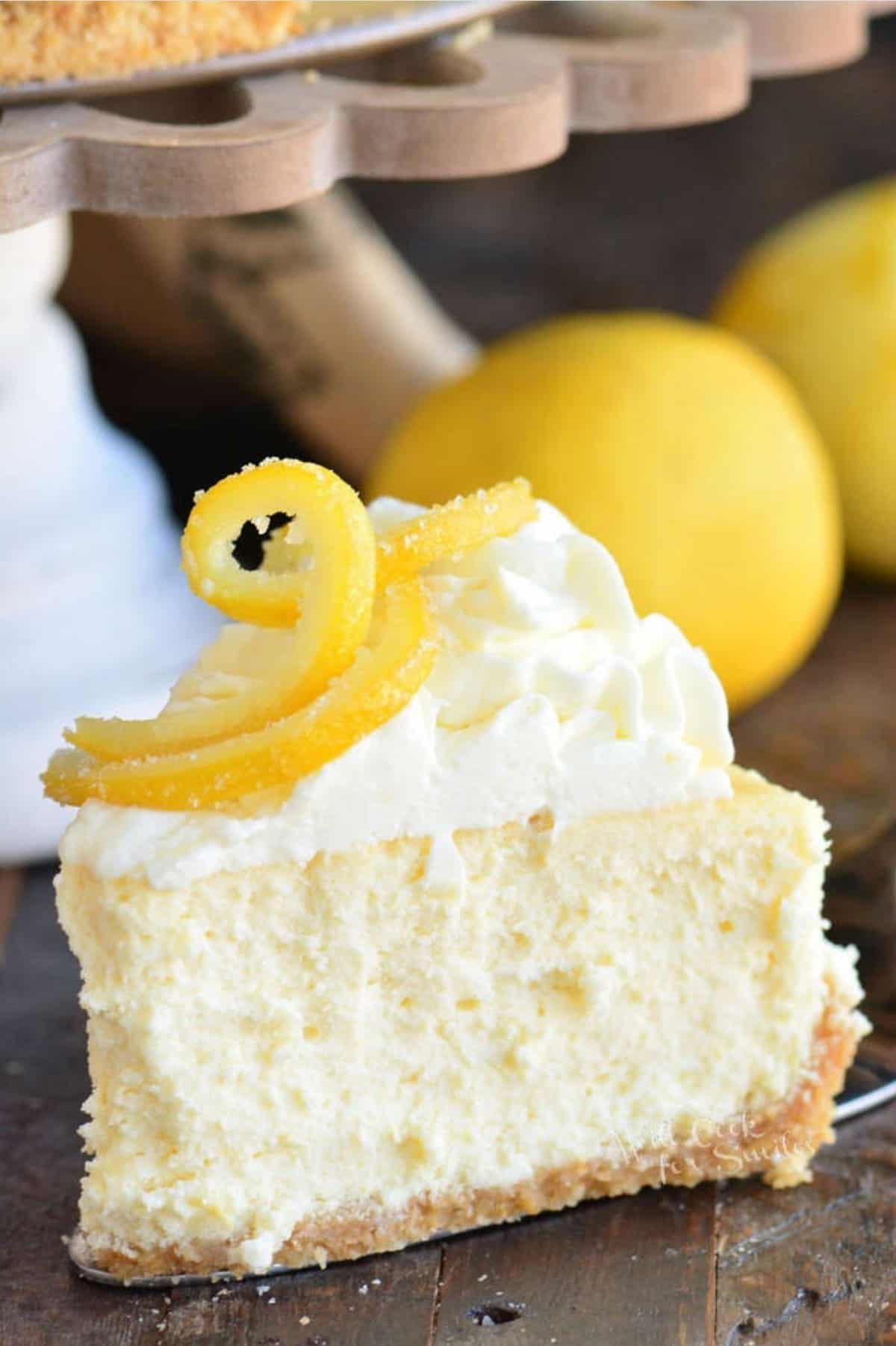 a piece of lemon cheesecake is topped with candied lemon and icing.