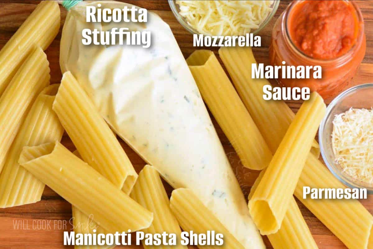 labeled ingredients for making manicotti on a wooden cutting board.