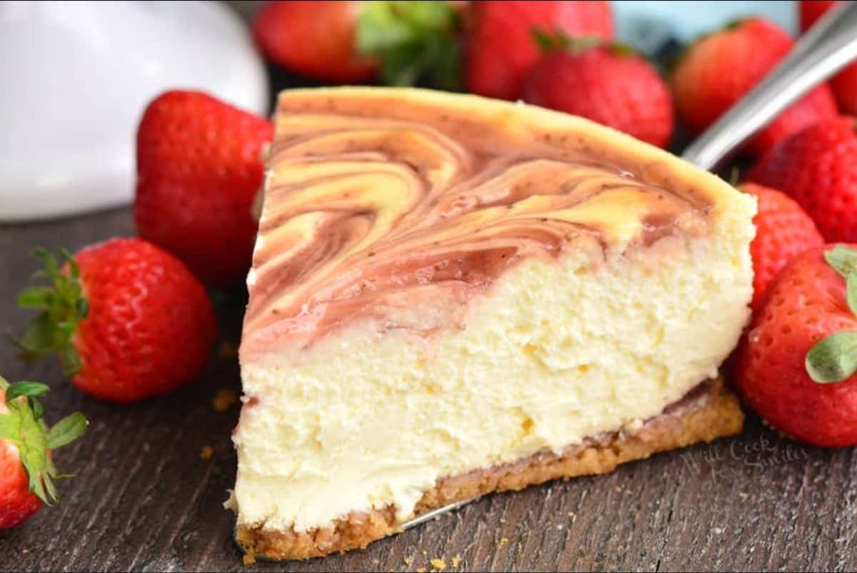 a slice of strawberry cheesecake with strawberries surrounding it.