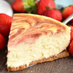 a slice of strawberry cheesecake on silver spatula with strawberries.