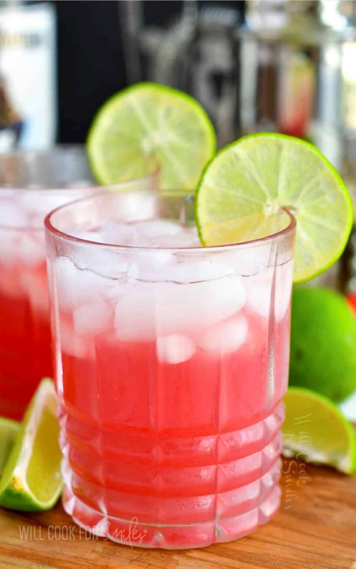 Pink Bay Breeze cocktail in the rocks glass with ice and a lime ring on the rim.