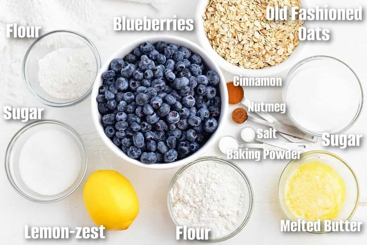 labeled ingredients to make blueberry crisp on a white board.