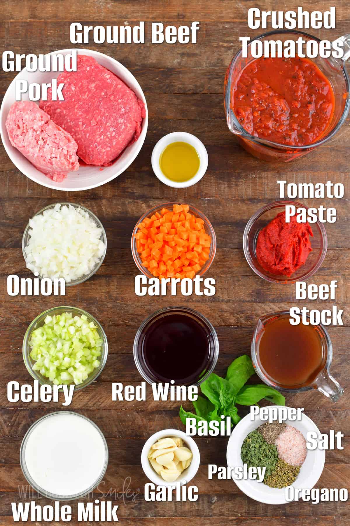 labeled ingredients to make Bolognese sauce on the wooden board.