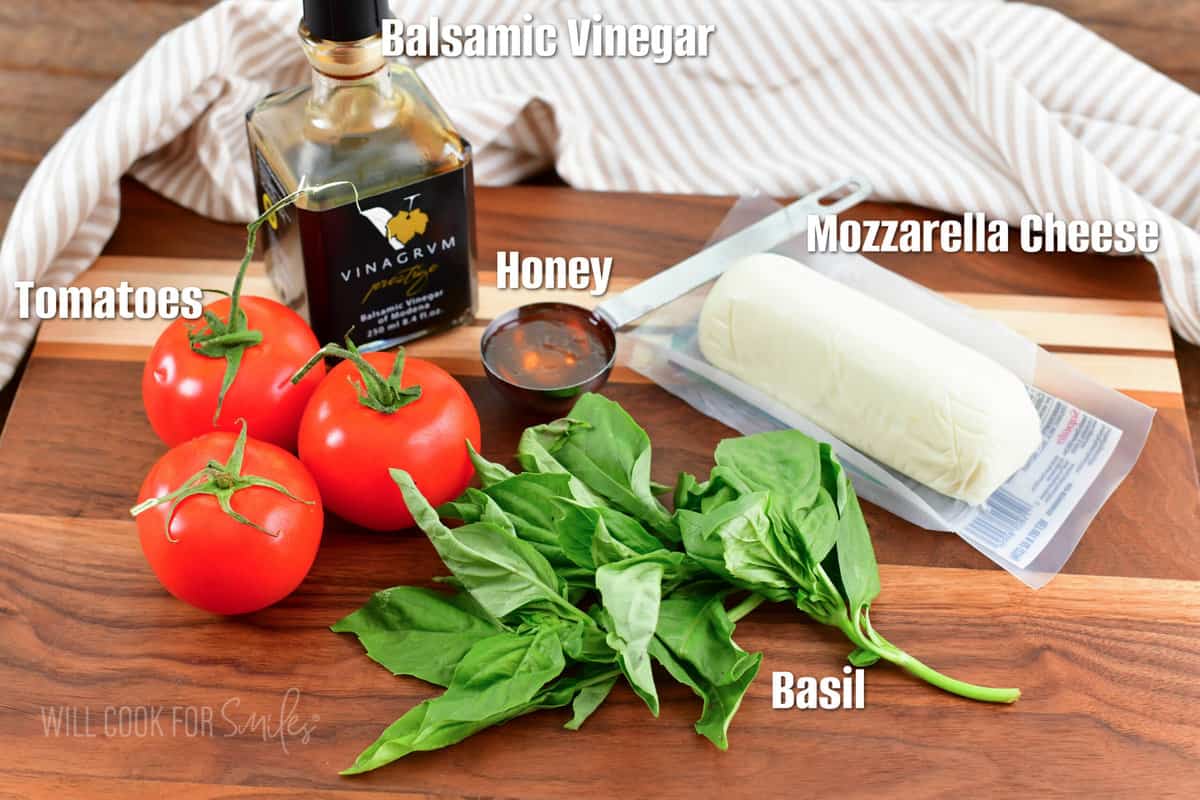 labeled ingredients to make caprese salad on the cutting board.
