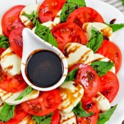 layered tomatoes and mozzarella cheese slices with basil leaves and balsamic reduction.