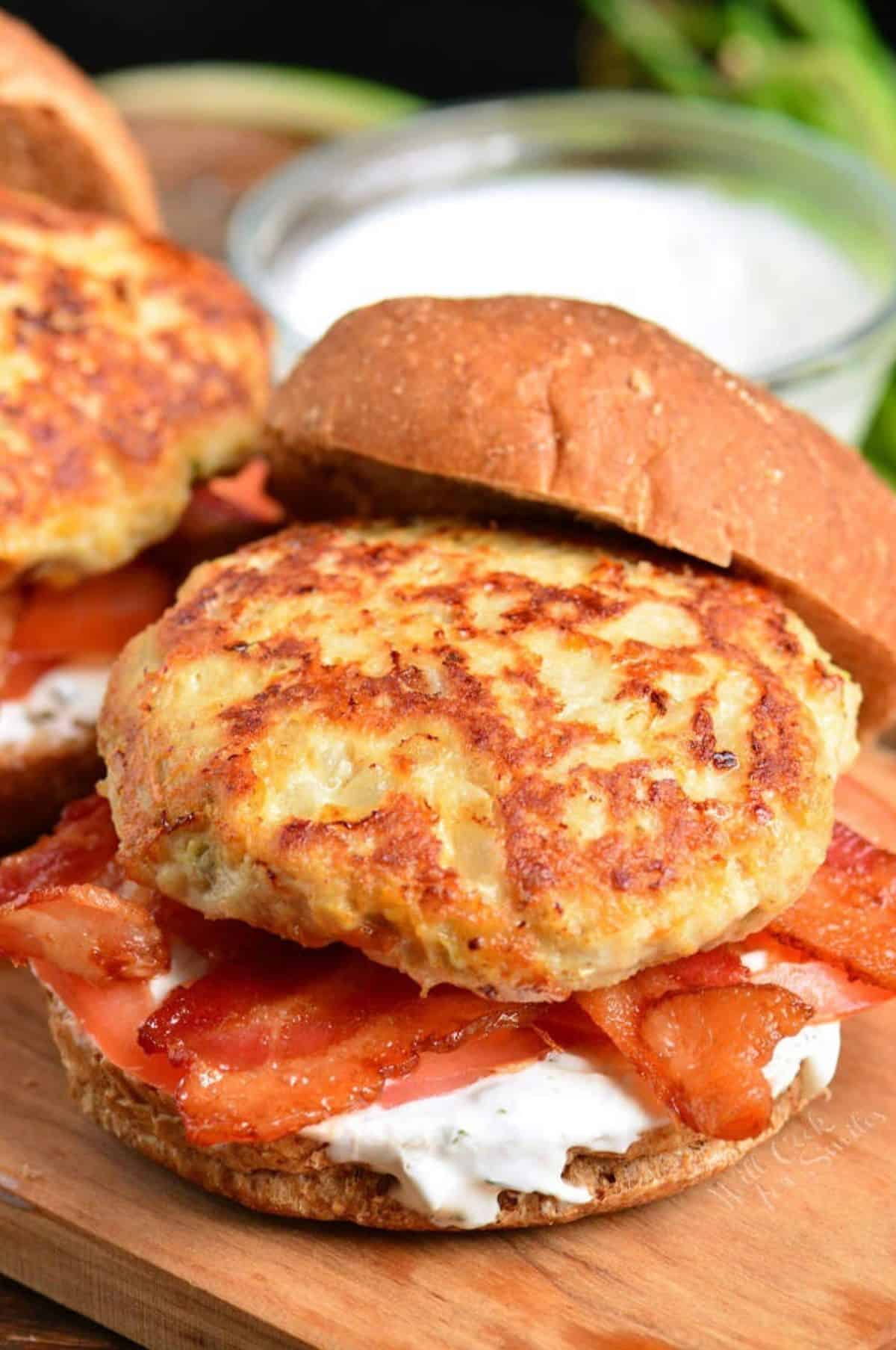 chicken burgers with bacon, tomato, and cream sauce on a bun.