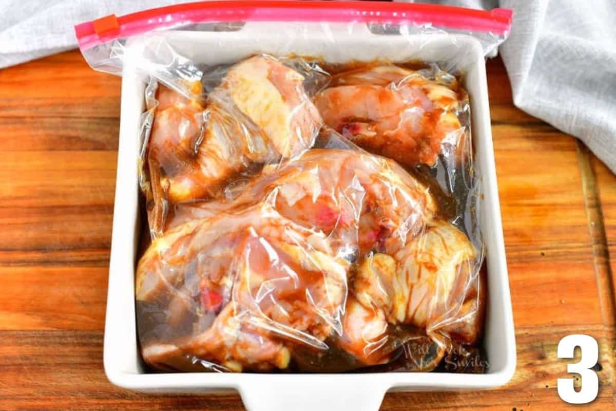 chicken marinating in the bag in a brown colored marinade.