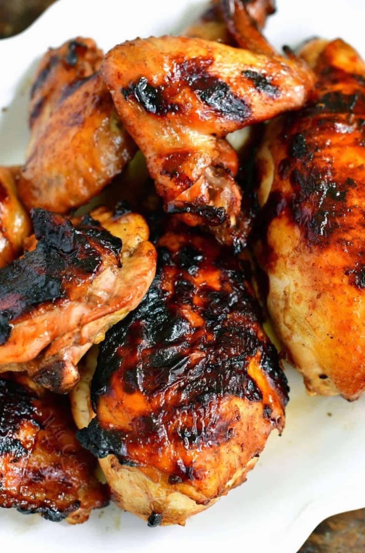 different cuts of grilled marinated chicken on the white plate.