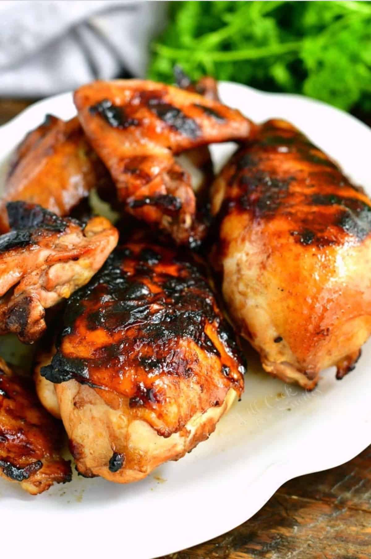 grilled chicken drumsticks, breasts, and wings on the white plate.