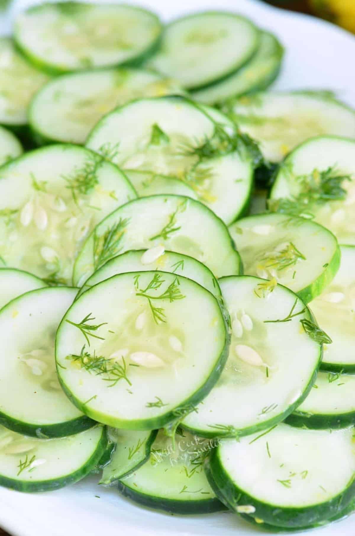 simple cucumber salad in a plate topped with dill weed.