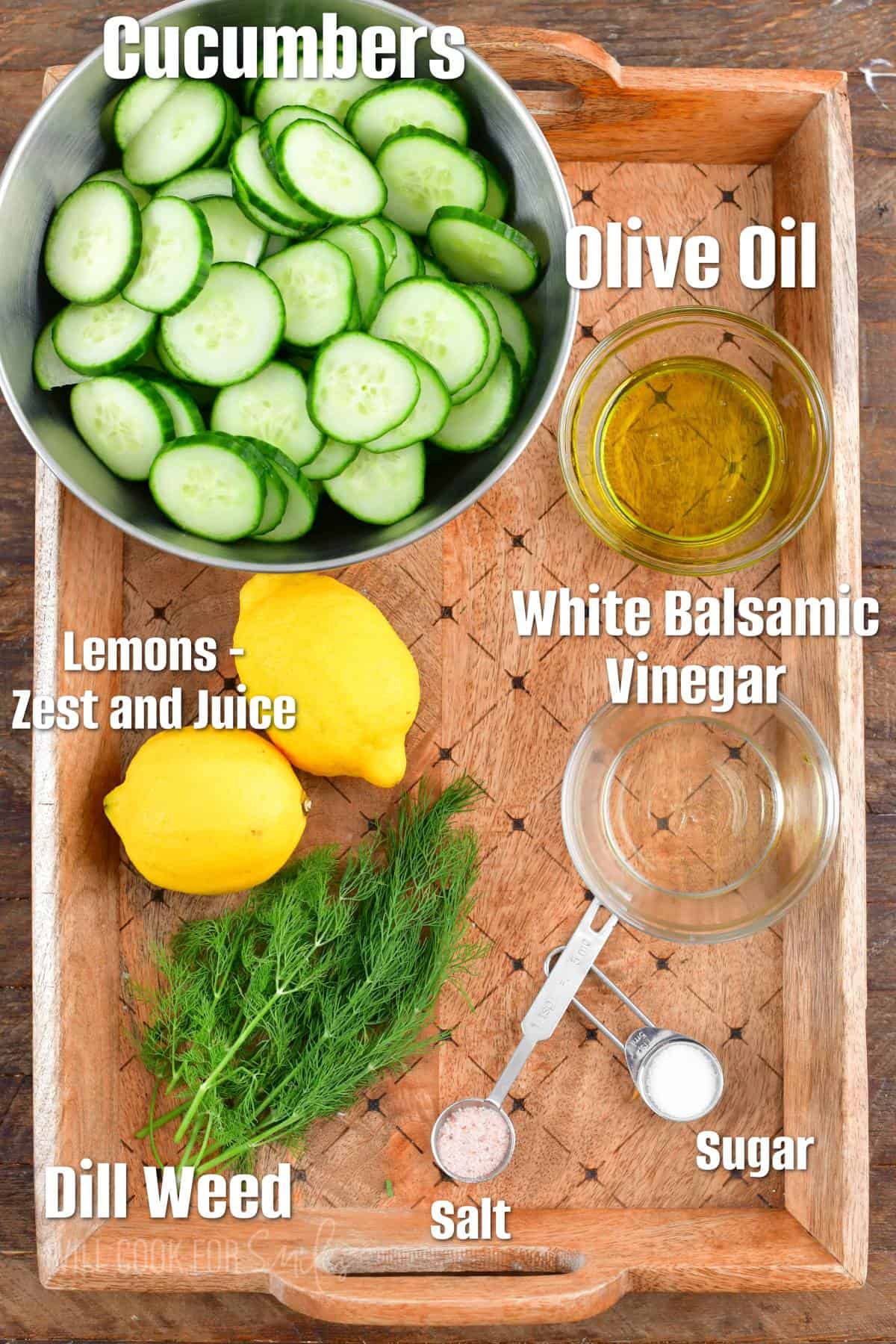 labeled ingredients to make cucumber salad on wooden background.