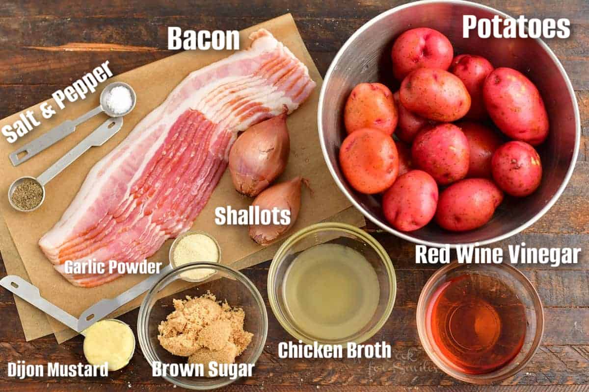 labeled ingredients to make German potato salad on a wooden board.
