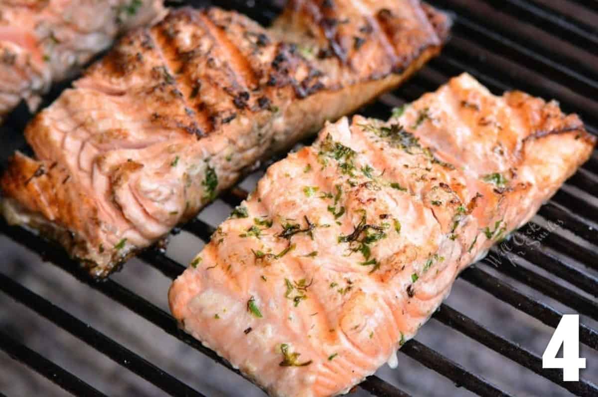 salmon filets cooking on the grill with top grill marks on salmon.