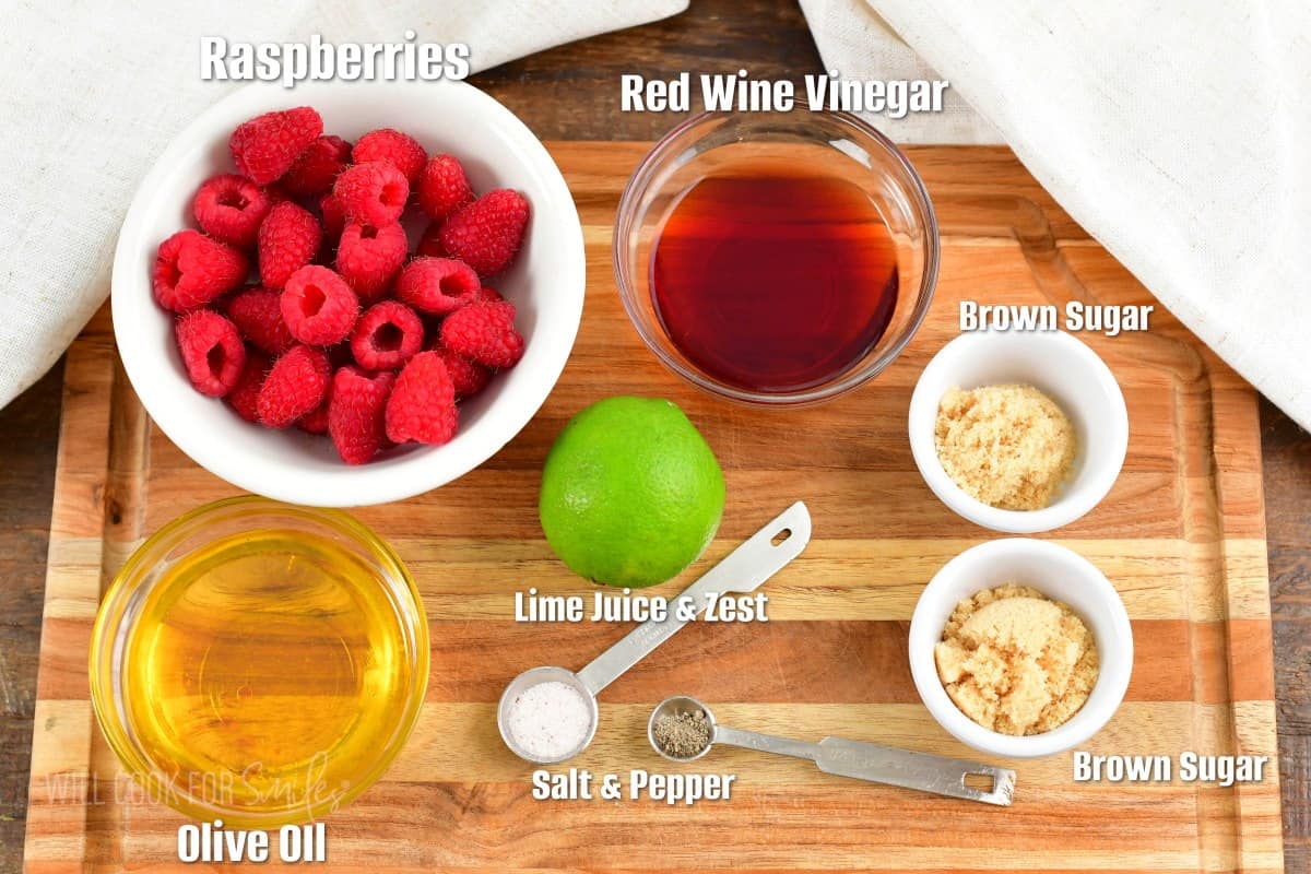 labeled ingredients to make raspberry vinaigrette on the cutting board.