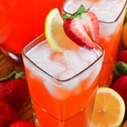 two glasses filled with strawberry lemonade and garnished with lemon slice and stawberry.